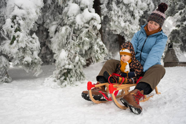 istock Playful mother having a fun time while sledding with her toddler boy 1347245820