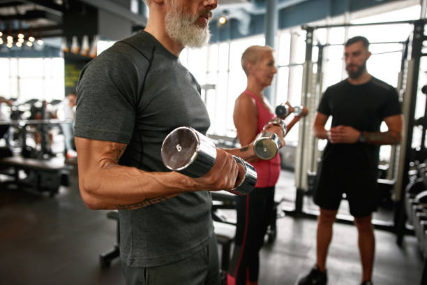 fit bleiben nach der pensionierung. porträt eines älteren muskulösen mannes - coach individuality organized group gym stock-fotos und bilder