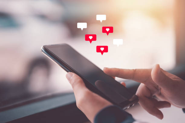 istock Woman hand using smartphone with heart icon at coffee shop background. 1347247610