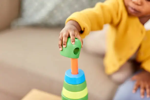 Photo of close up of african baby playing toy blocks