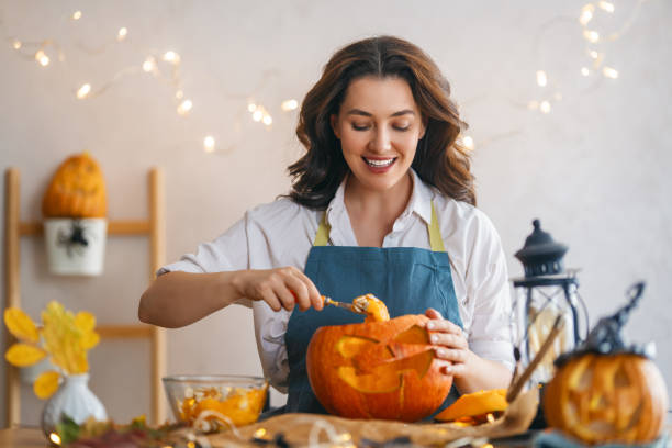 istock woman is carving pumpkin 1347249396