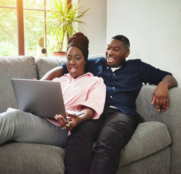 istock Shot of an affectionate young couple using a laptop together the sofa 1347250988