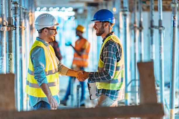 trabajadores de la construcción dándose la mano en el sitio de construcción - construction construction site handshake built structure fotografías e imágenes de stock