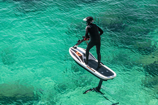Electronic Fliteboard with steering in emerald water at Kamenjak, Istria, Croatia 15.10.2021