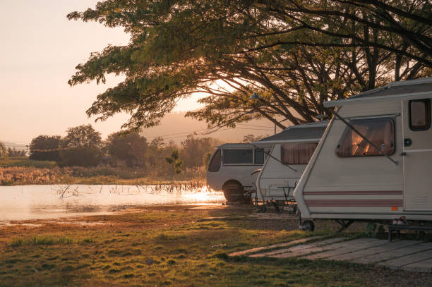 istock Motor home under big tree on campground by the lake in the evening 1347254177