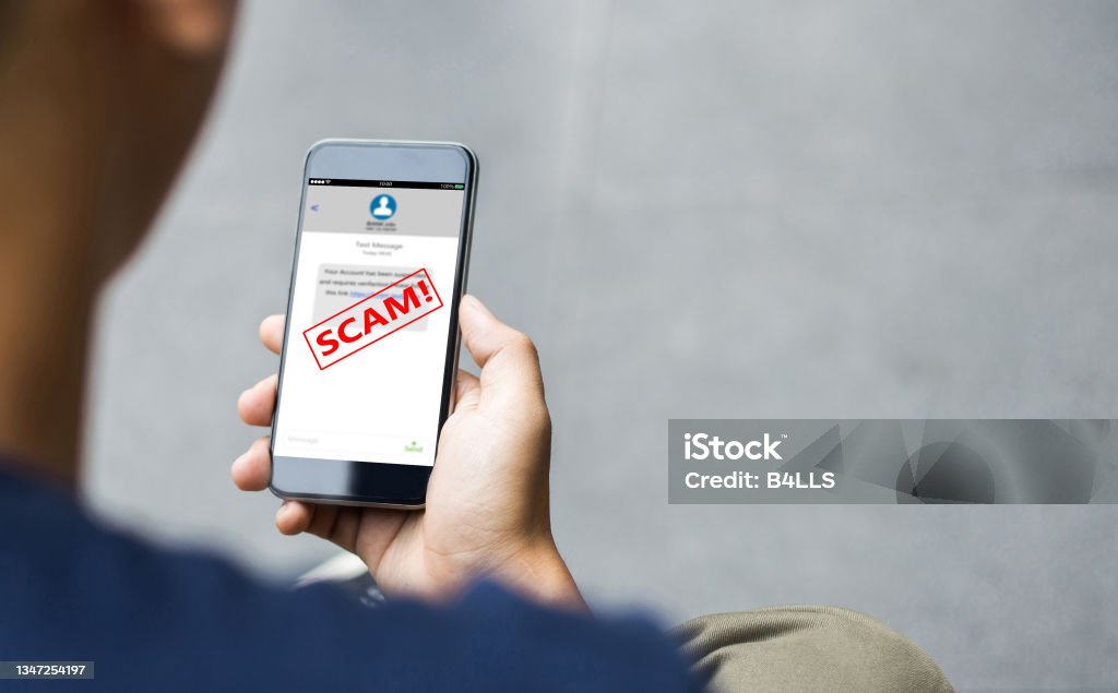 Text message SMS scam or phishing concept Man hands using smart phone Scammer Stock Photo