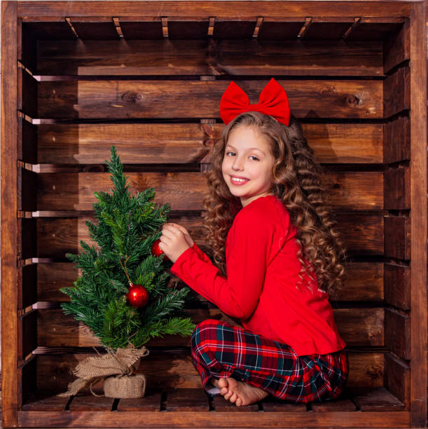 hermosa niña linda en una ubicación cuadrada de madera en decoraciones navideñas - portrait little girls 8 9 months hair bow fotografías e imágenes de stock