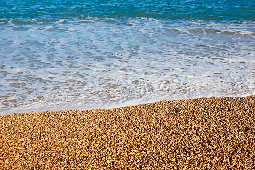 Mediterranean pebble beach and blue sea in Valencia. Spain