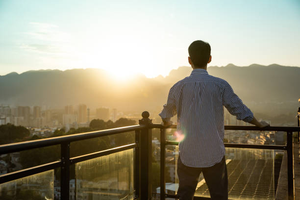 istock Young businessman standing rooftop looking sunset 1347257971