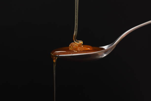Honey Fresh Honey pouring onto a spoon, focus on central bubble. High resolution image 45Mp using Canon EOS R5 with associate macro lens viscose stock pictures, royalty-free photos & images