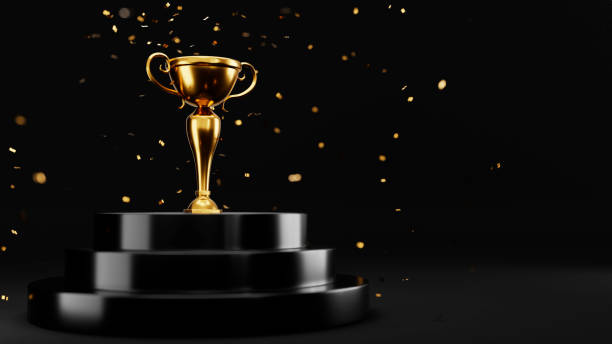 istock Golden cup on a podium isolated on black background 1347262895
