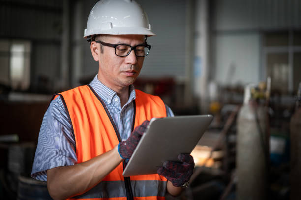 istock An Asian male blue-collar worker uses a computer in a factory 1347264481
