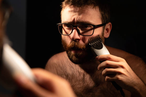 istock A man trims his beard in front of the mirror 1347264517