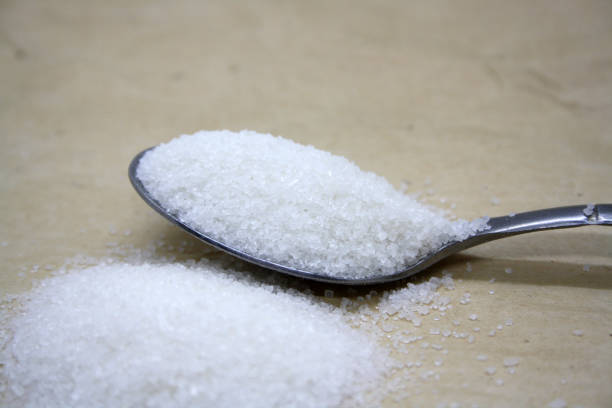 istock Sugar poured into a spoon on craft paper. 1347264882