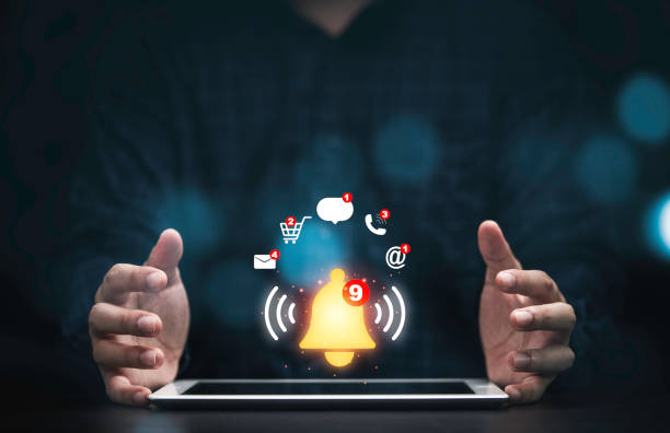 istock Businessman protecting tablet with virtual yellow bell ringing and icons for application notification alert concept. 1347264979