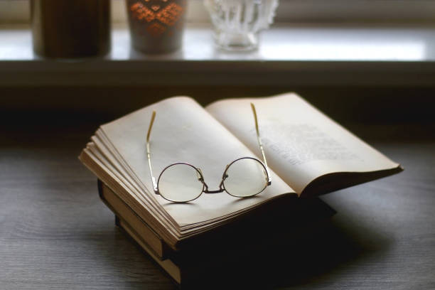 istock Book, Reading Glasses, Candles and Flowers 1347264991