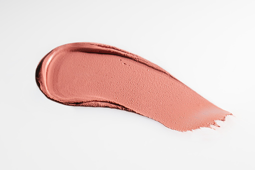 The texture of cream blush on a white background. Top view.