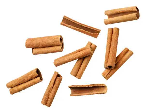 Photo of Cinnamon sticks falling on a white background, cut. Isolated