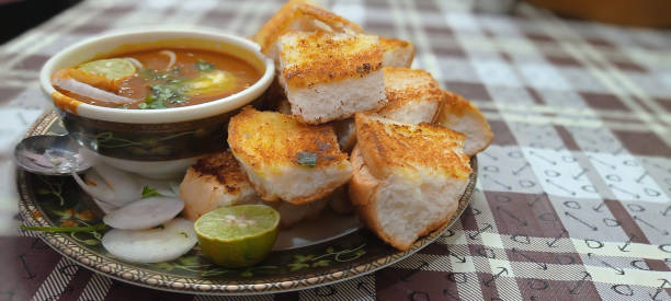 istock Delicious indian western dish pav bhaji with salad and lemon on patterned table 1347268039
