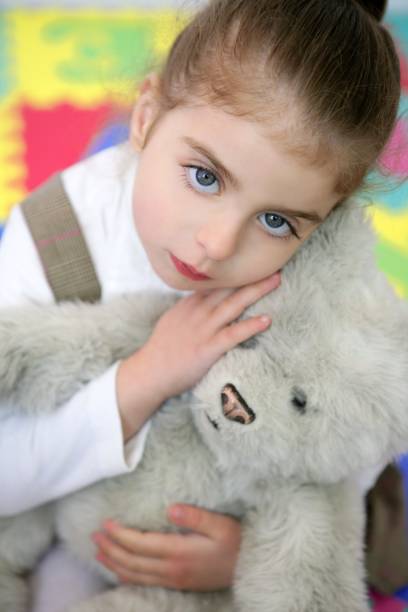 istock Beautiful little girl hug teddy bear 1347268201