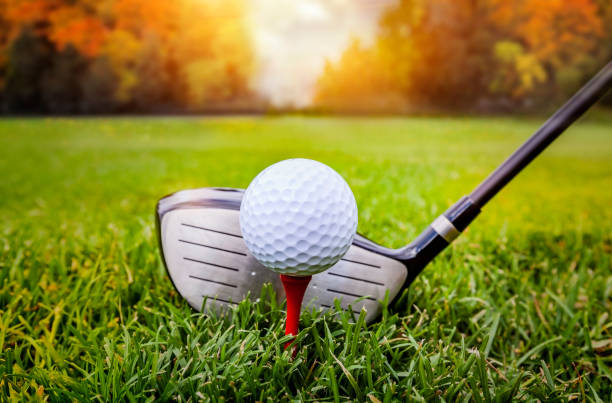 Golf ball and golf club in beautiful golf course at sunset background stock photo