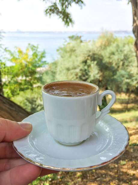 istock Hand holding Turkish coffee with nature and sea background 1347269872