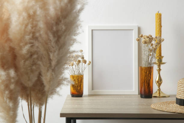 istock Wooden frame mockup on table with home interior decor elements. White wall background. Neutral color palette. 1347270925