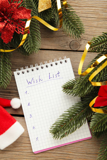 istock Christmas decorations and notebook with wish list on grey wooden background. Planning concept. 1347271186