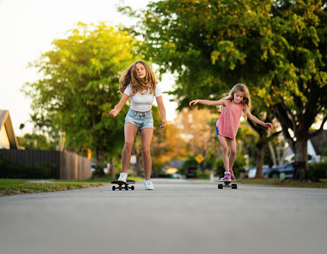 Best friends skateboarding on the neighborhood
