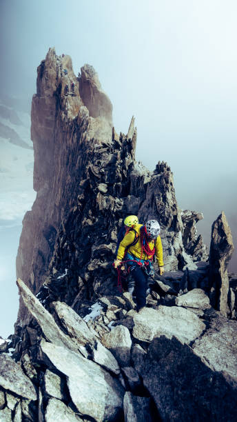 istock Team of climbers moving up the steep peak. Using rope, and climbing equipment 1347271993
