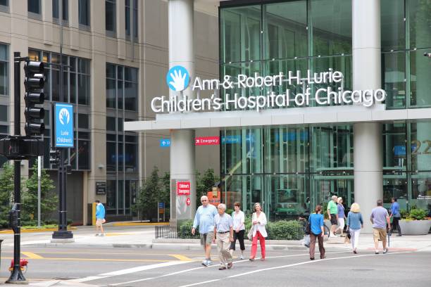 Children's Hospital of Chicago People walk by Ann and Robert H Lurie Children's Hospital of Chicago. lurie stock pictures, royalty-free photos & images