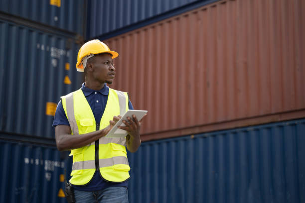 istock African worker holding a tablet, walking and checking the containers box from cargo ship for export and import 1347277479