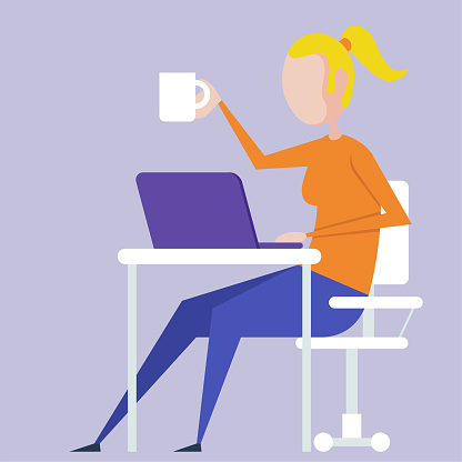 A woman works at a computer and drinks coffee
