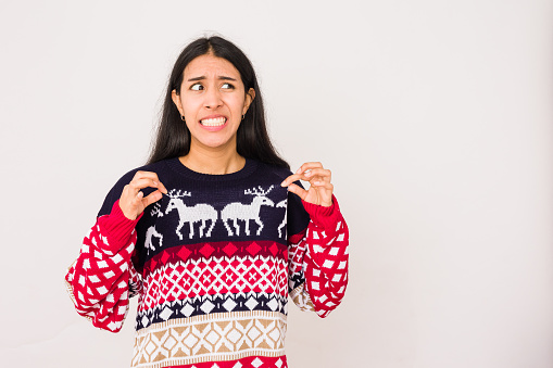 Regalo de Navidad convertido en una mala idea de Papá Noel en una mujer infeliz, suéter feo para la celebración de Navidad photo