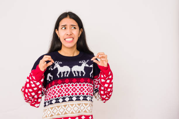 cadeau de noël devenir une mauvaise idée de père noël sur une femme malheureuse, pull moche pour la célébration de noël - laideur photos et images de collection