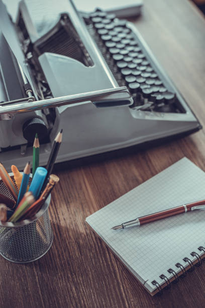 Writer or screenwriter creative concept. Notebook and vintage old typewriter at wooden desk table
