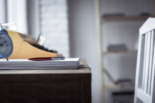 istock Pen on stack of paper and vintage old typewriter at wood desk table. Writer or study creative 1347288358