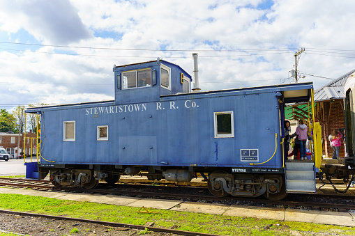 Stewartstown, PA, USA - October 17, 2021: The blue caboose at the Stewartstown Railroad station. The short-line railroad uses the former Union Pacific caboose for both train crews and passengers.
