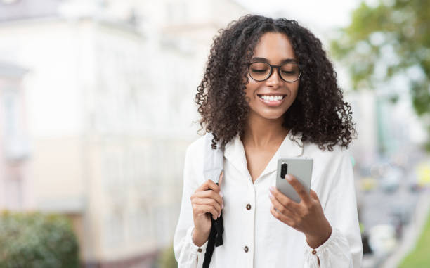 istock Happy woman using smart phone in a city 1347292448