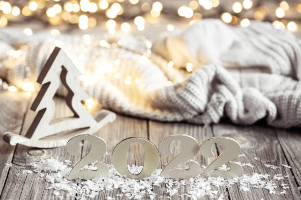 istock Cozy Christmas composition with number 2022 and decor details on blurred background with bokeh. 1347292550