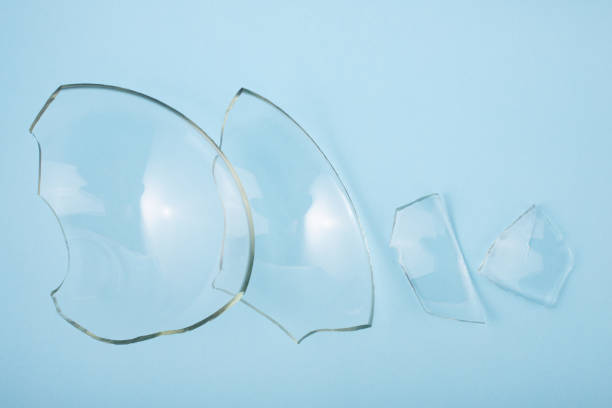 istock Broken glass pieces on pastel blue background. Close up, top view. 1347292617