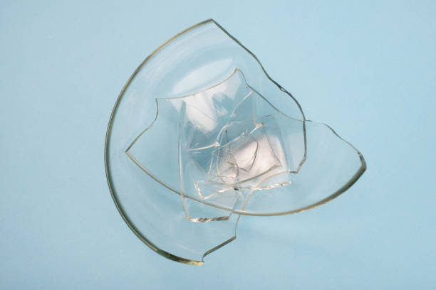 istock Broken glass pieces on pastel blue background. Close up, top view. 1347292679