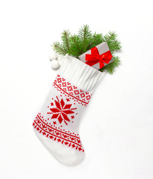 istock Christmas stocking white with a gift and fir branches on a light background. 1347292892