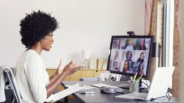Mid adult businesswoman participates in virtual meeting with colleagues