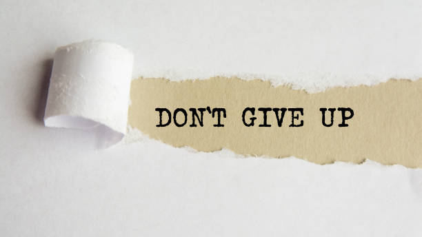 istock DONT GIVE UP. words. text on gray paper on torn paper background 1347294276