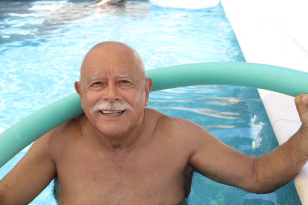 istock Senior man doing exercise in swimming pool 1347294282