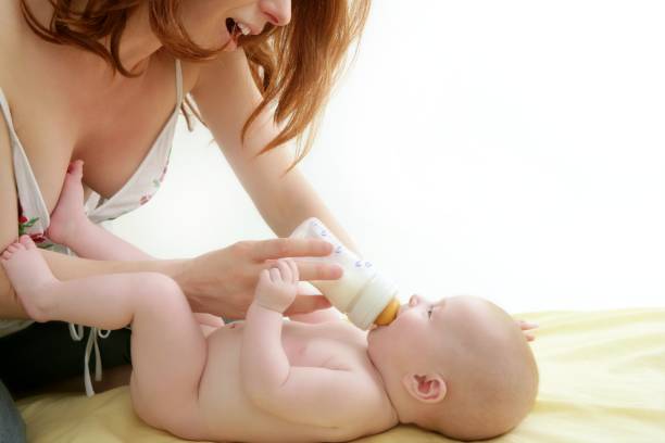 istock nude blond baby playing mother hands 1347295610