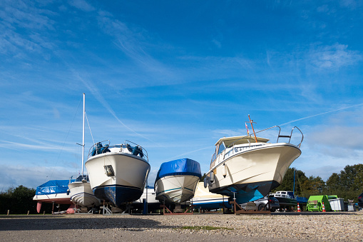 Drie polyester motorboten staan in de winterstalling bij een jachthaven aan het Veluwemeer.