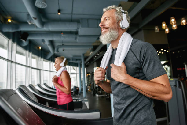 homme âgé heureux appréciant l’exercice dans la salle de gym - only senior men audio photos et images de collection