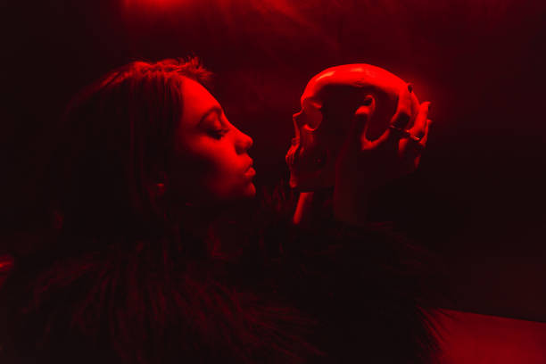 istock Gorgeous young woman looking at artificial skull. 1347299191